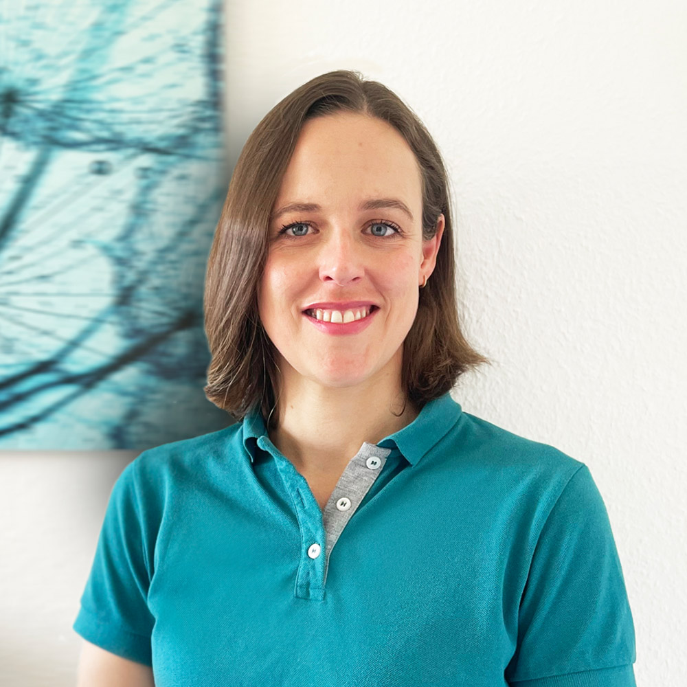 Porträtbild der Fachärztin – sie trägt ein Poloshirt in Petrol und steht vor einer weißen Wand. Im Anschnitt ist ein Bild mit einer Pusteblume im Farbton Petrol zu sehen.
